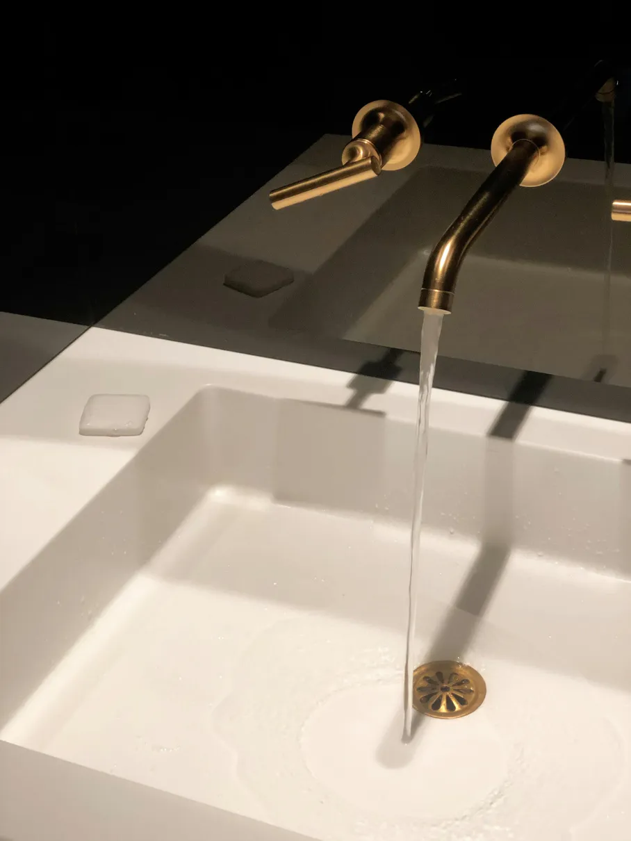 Un rubinetto in ottone con l’acqua che scorre